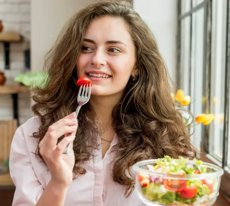 Woman eating a bowl of salad